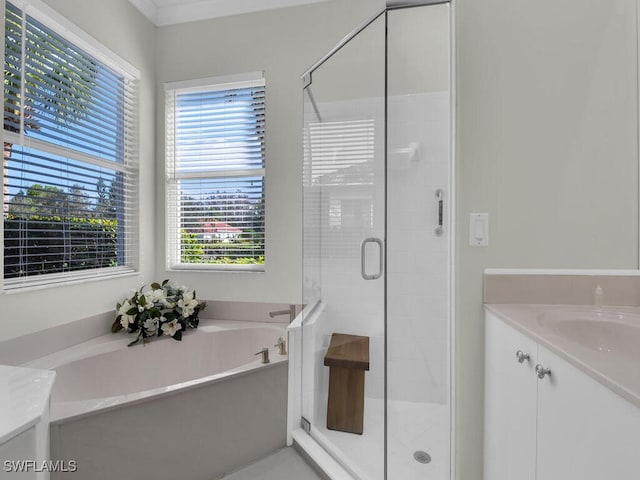 bathroom with vanity and shower with separate bathtub