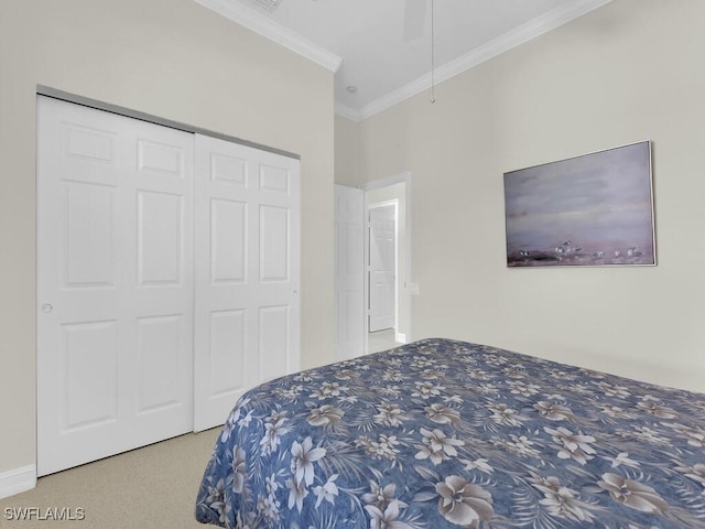 carpeted bedroom with ornamental molding and a closet