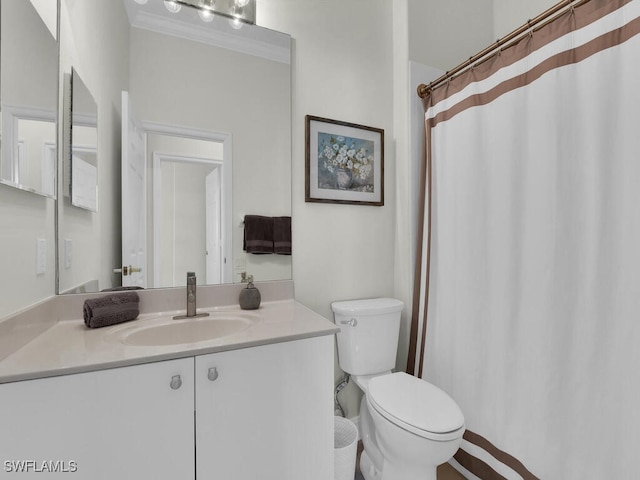 bathroom featuring vanity, crown molding, and toilet