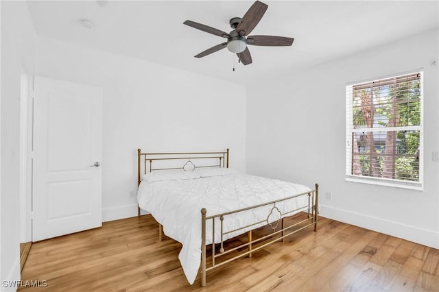 bedroom featuring baseboards, a ceiling fan, and light wood-style floors