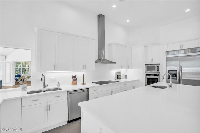 kitchen featuring built in appliances, wall chimney exhaust hood, a sink, and light countertops