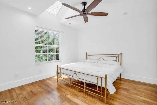 bedroom with light wood finished floors, recessed lighting, a skylight, and baseboards