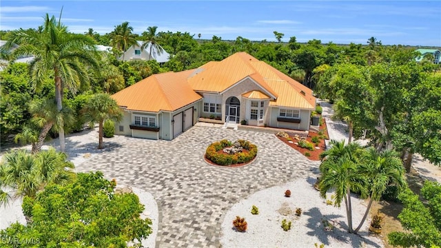 view of front of house with an attached garage, metal roof, and decorative driveway