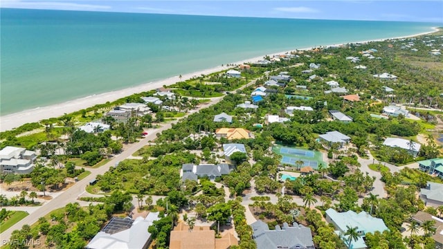 aerial view featuring a view of the beach, a water view, and a residential view