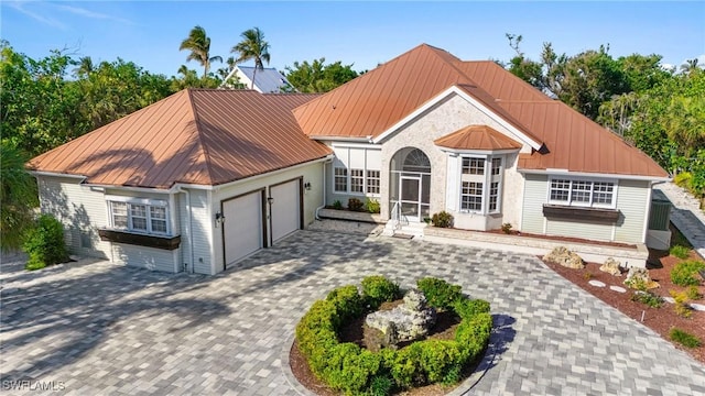 4090 W Gulf Dr, Sanibel, FL 33957 - view of front of home featuring an attached garage, metal roof, decorative driveway, and a standing seam roof