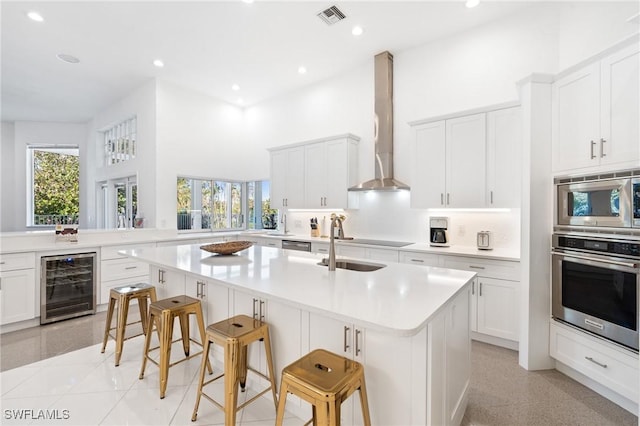 4090 W Gulf Dr, Sanibel, FL 33957 - kitchen featuring visible vents, wine cooler, light countertops, stainless steel appliances, and wall chimney exhaust hood
