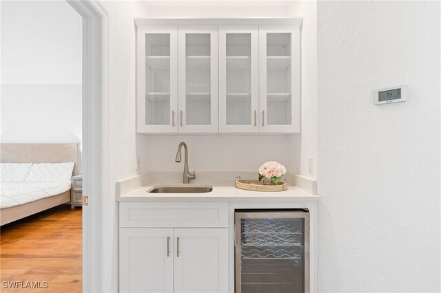4090 W Gulf Dr, Sanibel, FL 33957 - bar featuring indoor wet bar, beverage cooler, light wood finished floors, and a sink