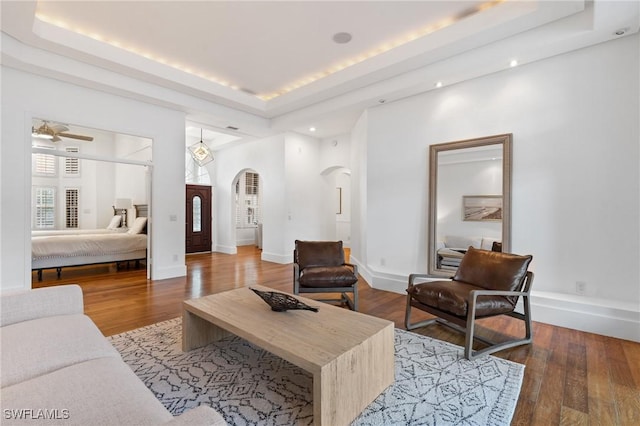 4090 W Gulf Dr, Sanibel, FL 33957 - living area featuring arched walkways, a tray ceiling, and wood finished floors