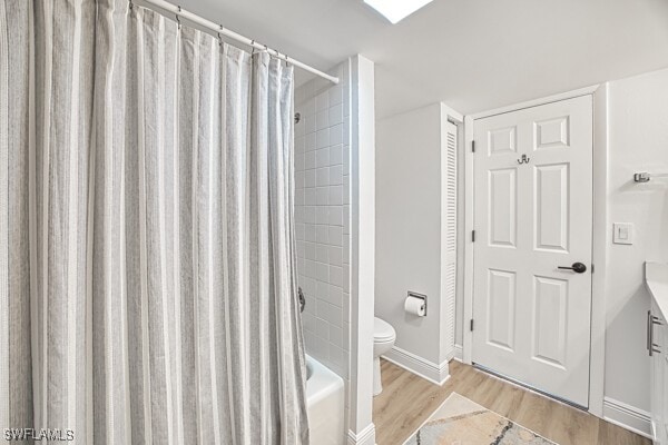 full bathroom with vanity, hardwood / wood-style floors, toilet, and shower / tub combo with curtain