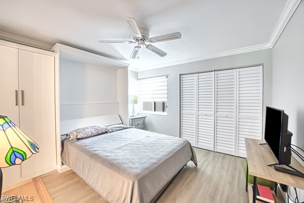 bedroom with crown molding, light hardwood / wood-style floors, a closet, and ceiling fan