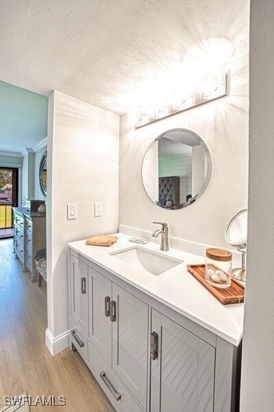 bathroom featuring hardwood / wood-style flooring, vanity, and a textured ceiling