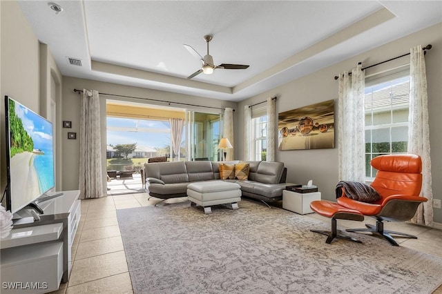 sitting room featuring light tile patterned floors, ceiling fan, and a tray ceiling