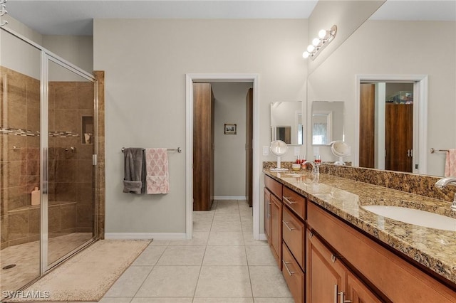 bathroom featuring tile patterned flooring, vanity, and a shower with door