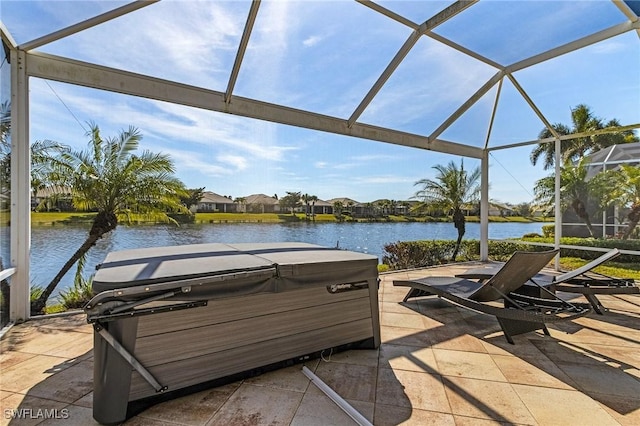 view of patio with a water view, a hot tub, and a lanai