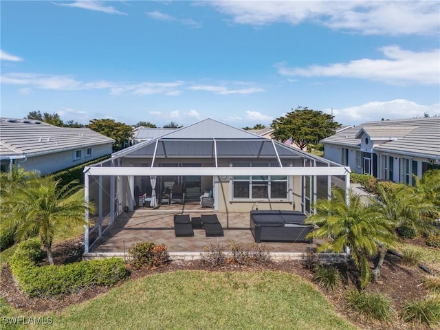 back of property with a yard, glass enclosure, and a patio area