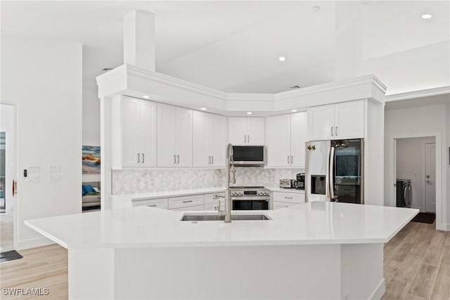 kitchen featuring white cabinetry, stainless steel appliances, light hardwood / wood-style floors, and a large island with sink