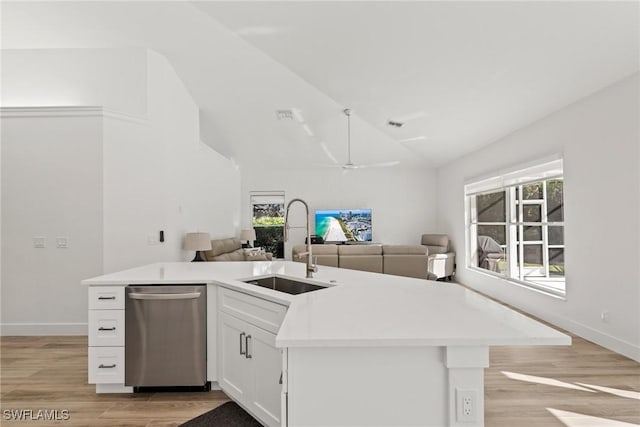 kitchen with white cabinetry, lofted ceiling, sink, stainless steel dishwasher, and light hardwood / wood-style flooring