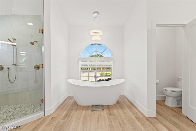 bathroom featuring wood-type flooring, toilet, and separate shower and tub