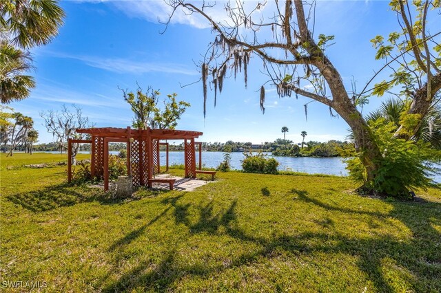 view of yard featuring a water view and a pergola