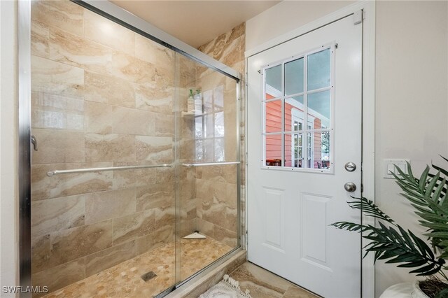 bathroom featuring a shower with shower door