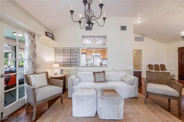 sitting room featuring hardwood / wood-style flooring, crown molding, high vaulted ceiling, and an inviting chandelier