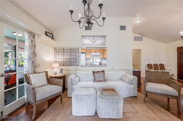 sitting room with hardwood / wood-style flooring, high vaulted ceiling, a chandelier, and crown molding