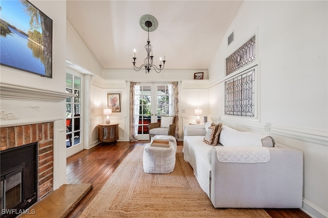 living area featuring a brick fireplace, high vaulted ceiling, french doors, and hardwood / wood-style flooring