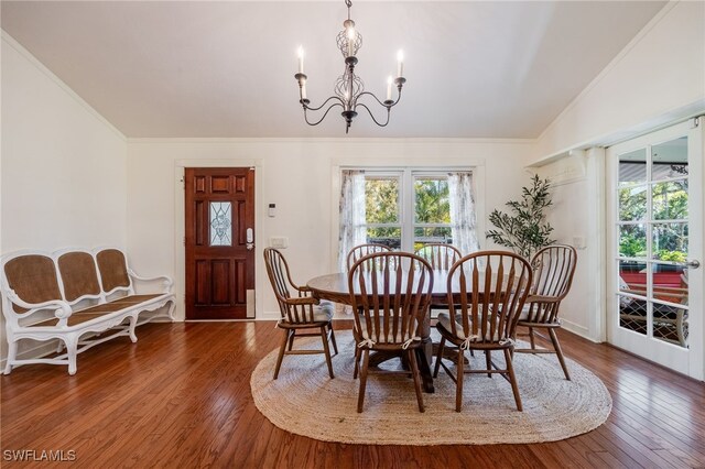 dining space featuring vaulted ceiling, crown molding, a chandelier, and dark hardwood / wood-style flooring