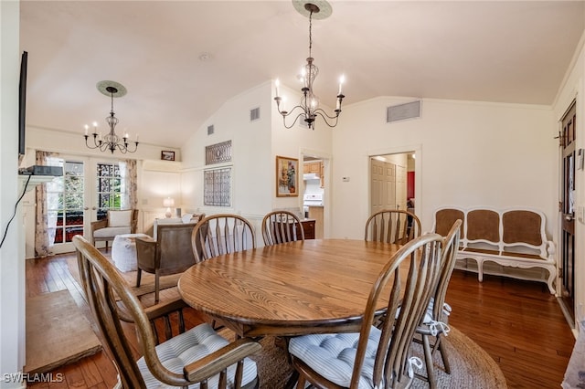 dining room featuring dark wood-type flooring, ornamental molding, a chandelier, and vaulted ceiling