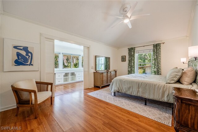 bedroom with hardwood / wood-style floors, ornamental molding, and ceiling fan