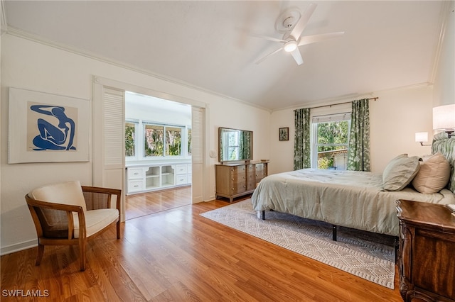 bedroom featuring hardwood / wood-style flooring, ornamental molding, and ceiling fan