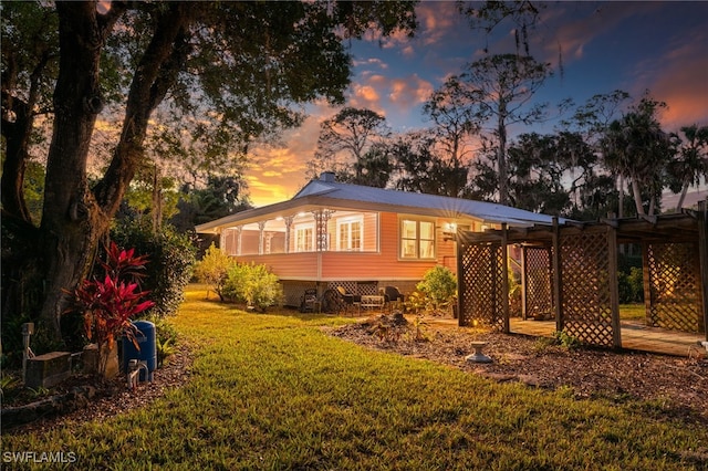 back house at dusk with a lawn