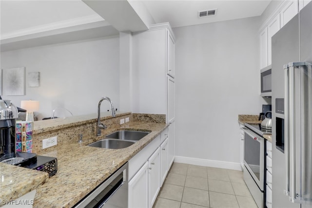 kitchen featuring white cabinetry, sink, light stone countertops, and appliances with stainless steel finishes