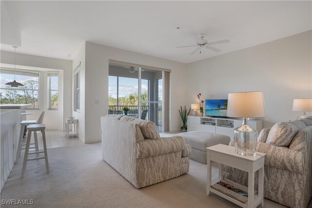 carpeted living room with ceiling fan and plenty of natural light