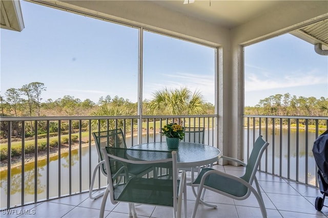 sunroom / solarium featuring a water view