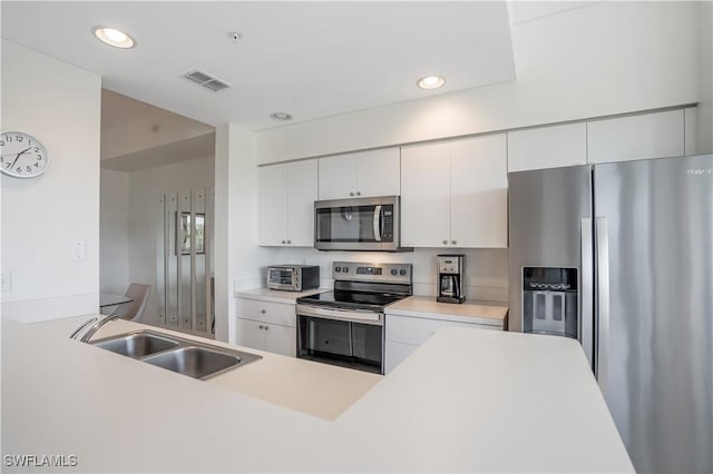 kitchen featuring white cabinetry, sink, and appliances with stainless steel finishes