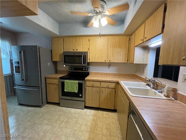 kitchen with sink, stainless steel appliances, ceiling fan, and light brown cabinets