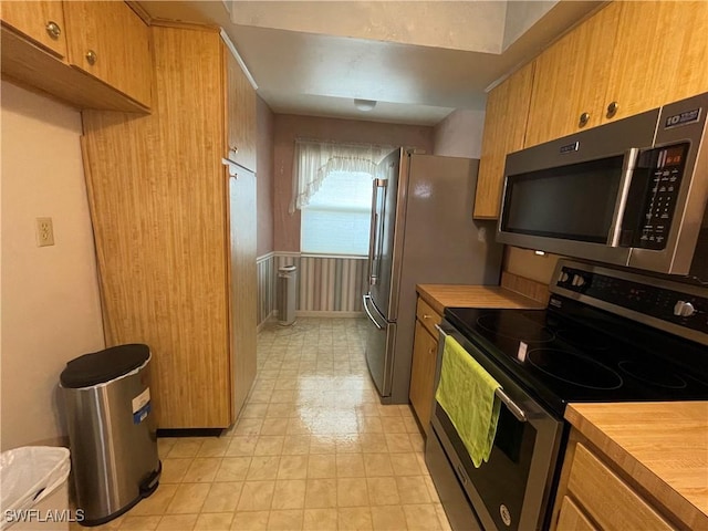 kitchen featuring stainless steel appliances and butcher block counters