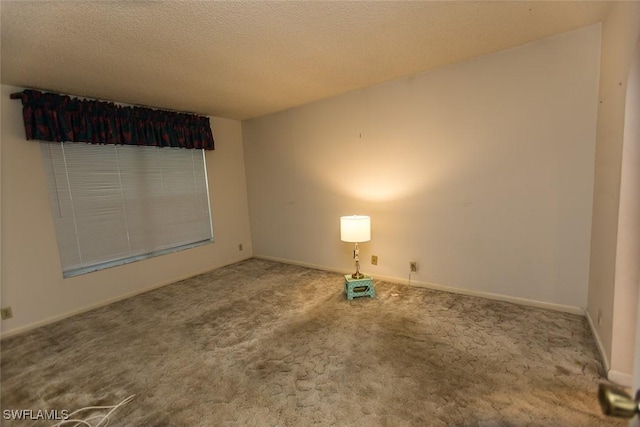 carpeted spare room featuring a textured ceiling