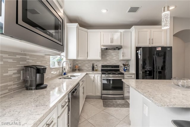 kitchen with pendant lighting, white cabinetry, sink, backsplash, and stainless steel appliances