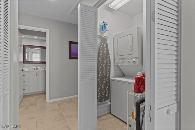 washroom featuring light tile patterned flooring and stacked washer and dryer