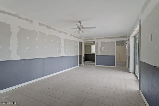 unfurnished room with light tile patterned floors and ceiling fan