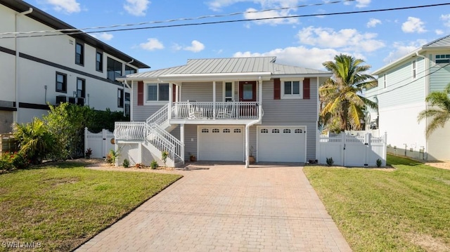 view of front of property with a garage, a front yard, and covered porch