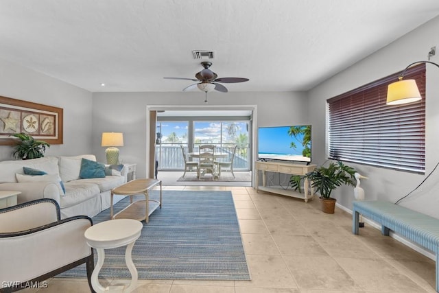 tiled living room with ceiling fan