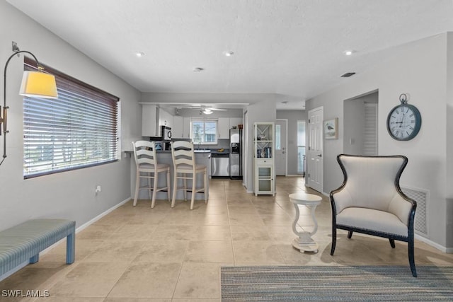 tiled living room featuring ceiling fan