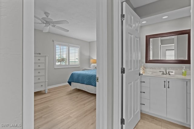 bedroom with ceiling fan and sink