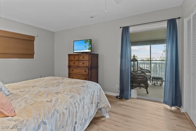 bedroom featuring light wood-type flooring, a closet, and access to outside