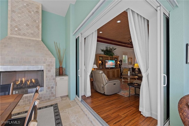 interior space with light wood finished floors, a brick fireplace, and recessed lighting