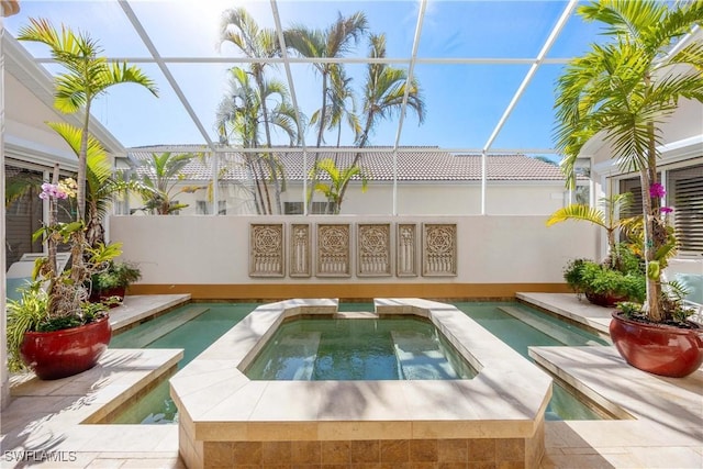 view of swimming pool with an in ground hot tub and glass enclosure