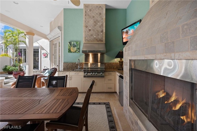 tiled dining space featuring sink and a tile fireplace